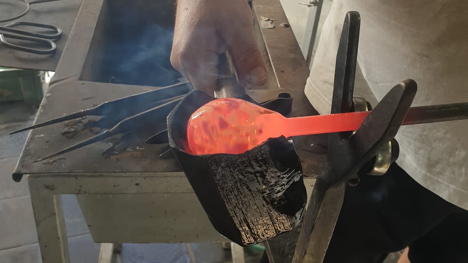 After the colored shards are melted into the glass, the surface is formed into a round shape using a wooden, spoon-shaped shaping tool (block). Photo: Archive of the Czech Center New York After the colored shards are melted into the glass, the surface is formed into a round shape using a wooden, spoon-shaped shaping tool (block). Photo: Archive of the Czech Center New York