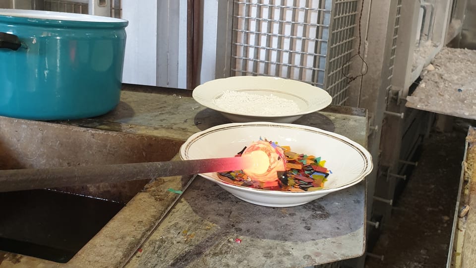 The molten glass is then covered in pre-prepared colored shards to achieve the desired color. Photo: Archive of the Czech Center New York The molten glass is then covered in pre-prepared colored shards to achieve the desired color. Photo: Archive of the Czech Center New York