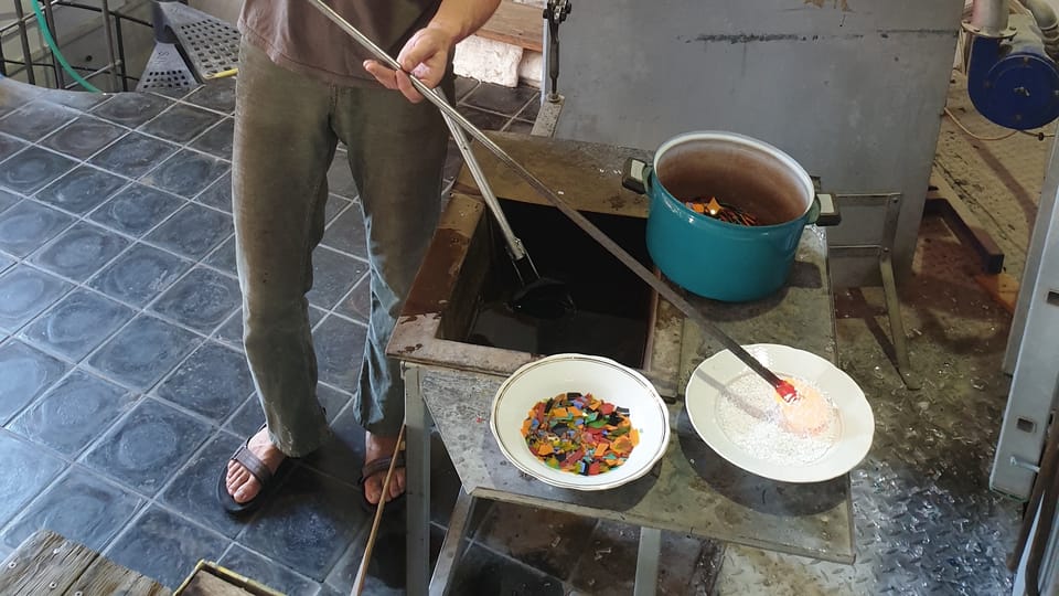 After gathering the molten glass,  the glassmaker rolls the clear glass into white crushed glass  (frit). Photo: Archive of the Czech Center New York